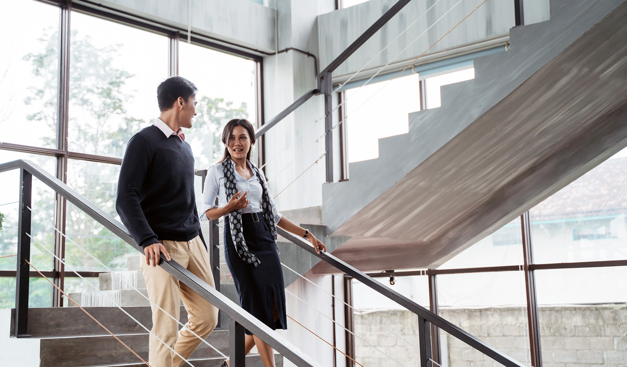 Contact MiTek - Man and woman walking down a set of stairs talking