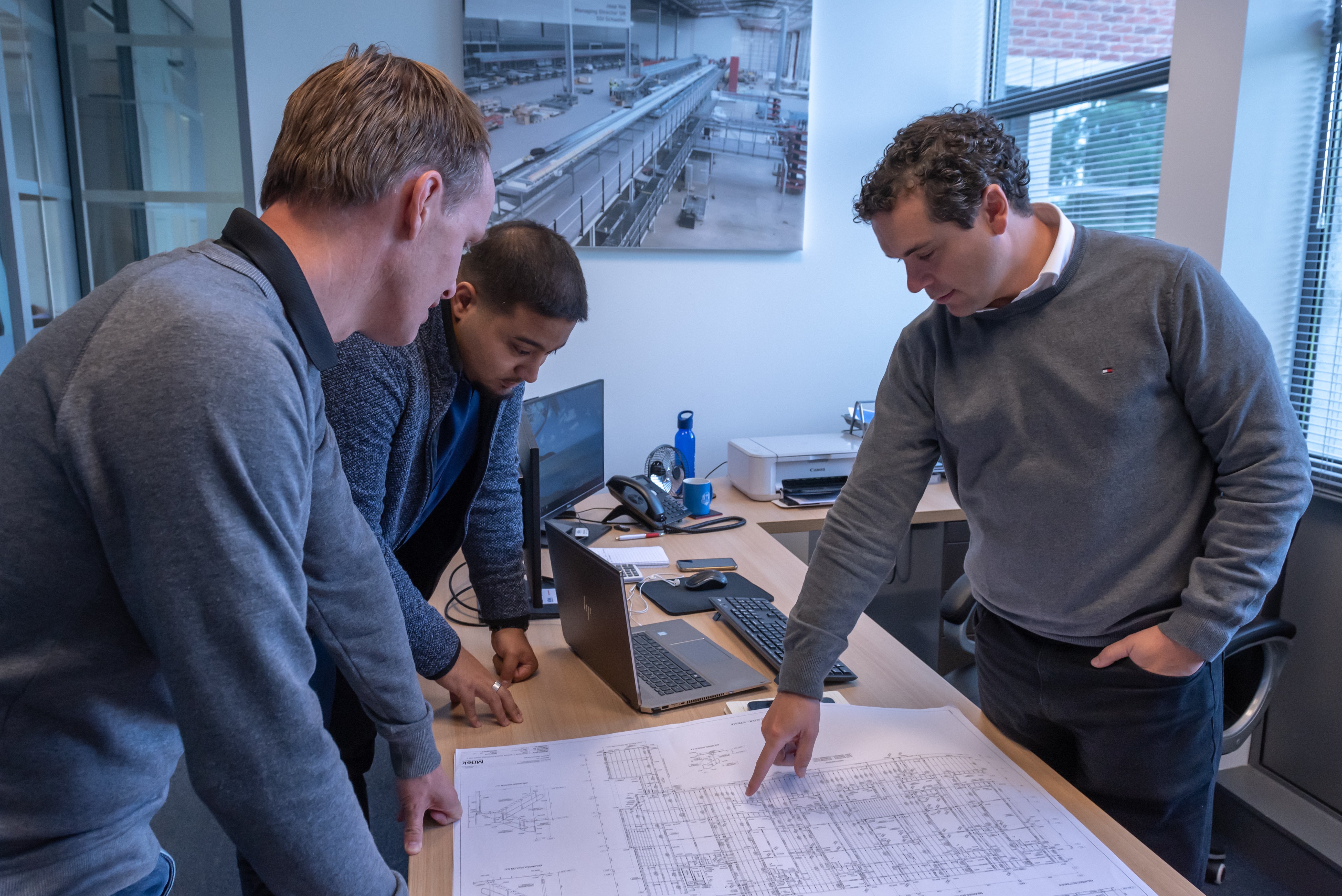 MiTek team consults on building plans.