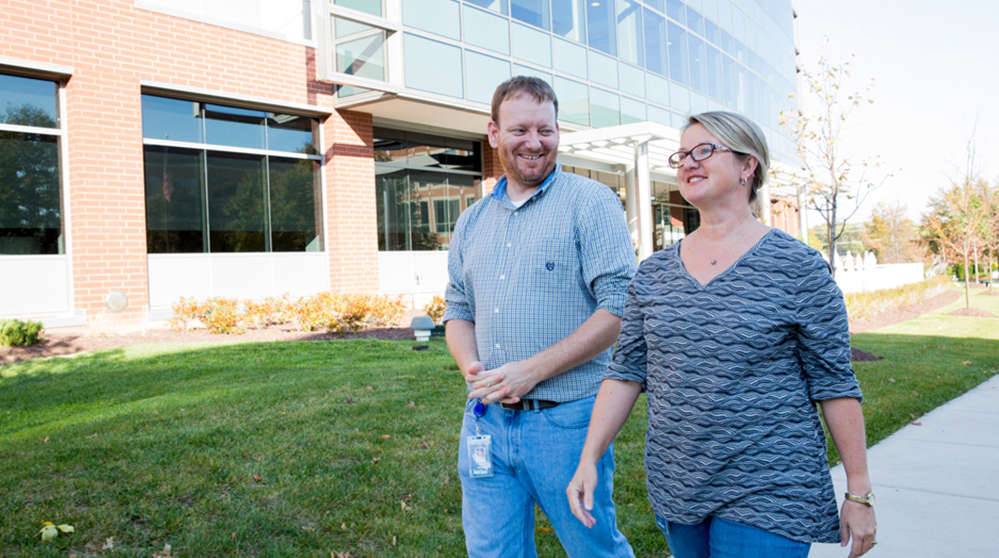 Career and Growth Opportunities at MiTek - A man and woman walk outside of the MiTek corporate office