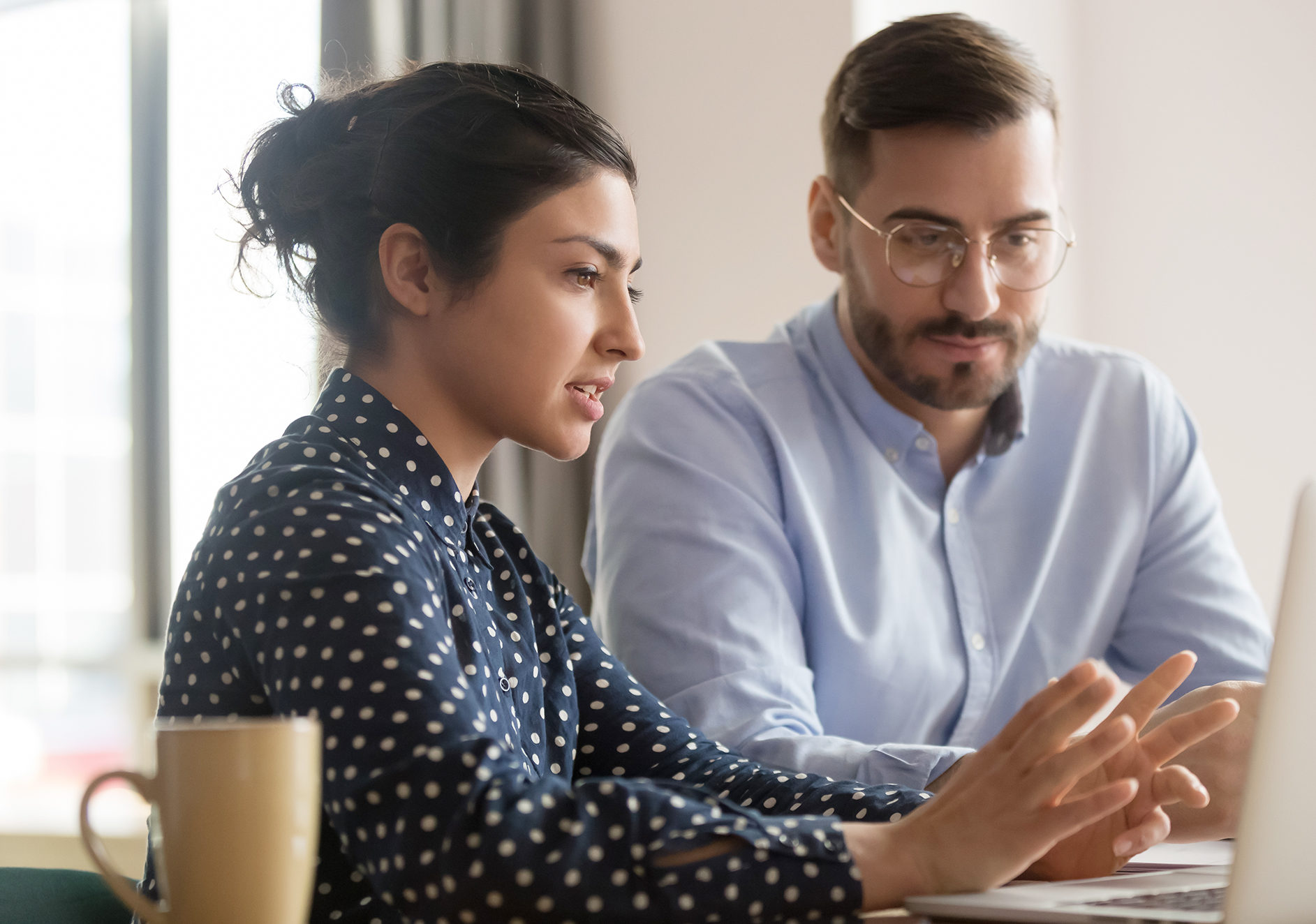 Career and Opportunities at MiTek - A woman and a man sit at a shared laptop having a discussion