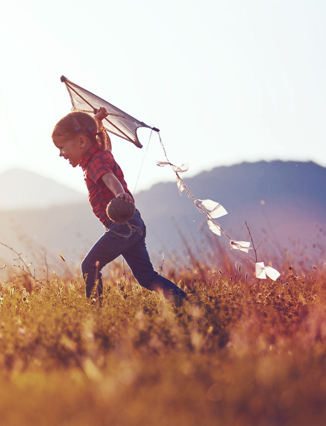 MiTek's commitment to communities - Girl running in the grass with a kite