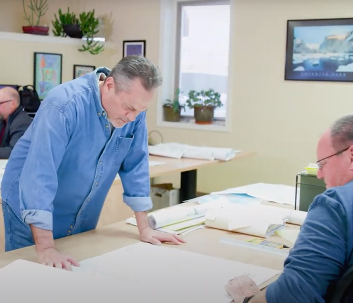 MiTek Resources Training Quality Control Management Services - Two men standing at desk looking over drawings