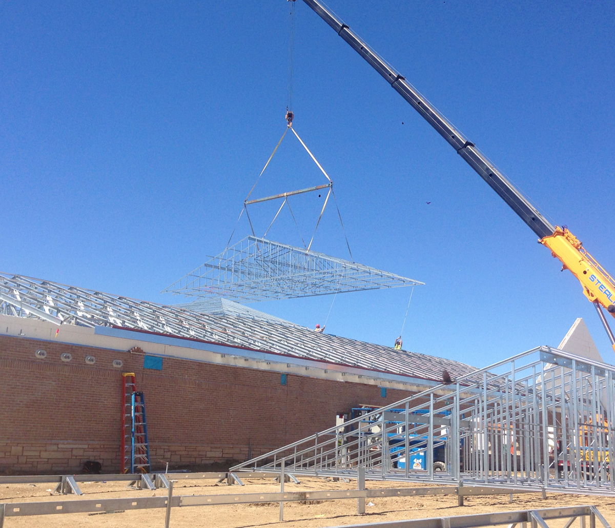 MiTek Ultra-Span Roof Truss Engineered Systems Products - Cold-formed steel roof truss being hoisted into place by crane