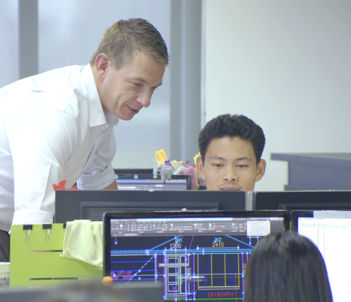 MiTek Structural Value Engineering Innovation Services - Deux hommes à un bureau travaillant sur un ordinateur.