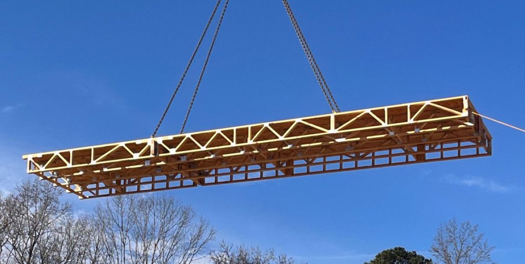 An Open Web Floor Truss on site, lifted by a crane in the sunshine